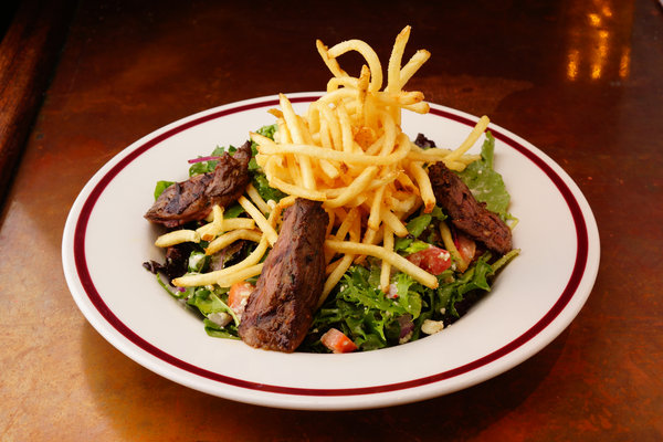 Steak frites salad with grilled skirt steak and shoestring potatoes at La Creperie Cafe